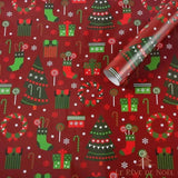 Rouleau de papier cadeau rouge déroulé, sapins verts, chaussettes, couronnes et cannes de bonbon