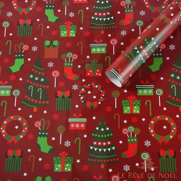 Rouleau de papier cadeau rouge déroulé, sapins verts, chaussettes, couronnes et cannes de bonbon