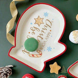 Assiette blanche en forme de moufle, bord rouge, macaron vert posé dessus, sucre d'orge peint