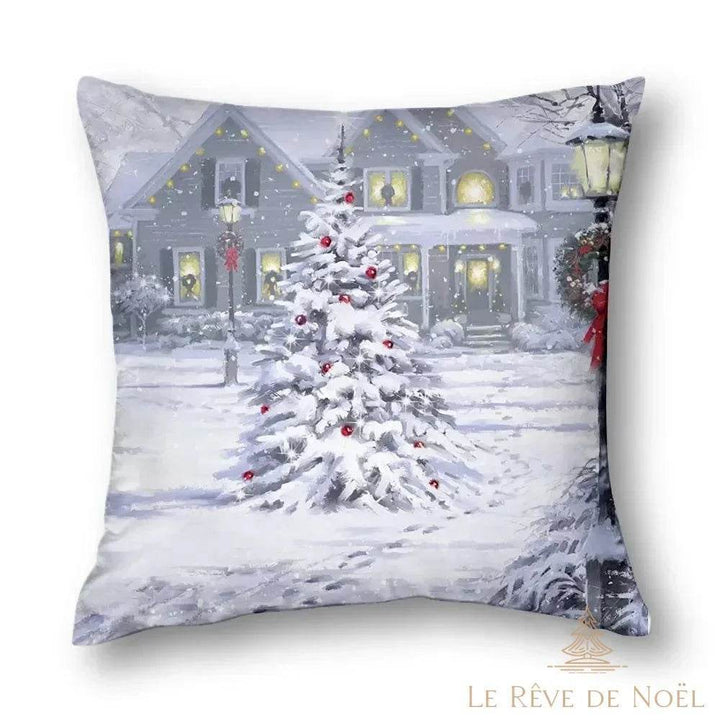 Housse de coussin carrée imprimée : sapin enneigé aux boules rouges devant une maison illuminée