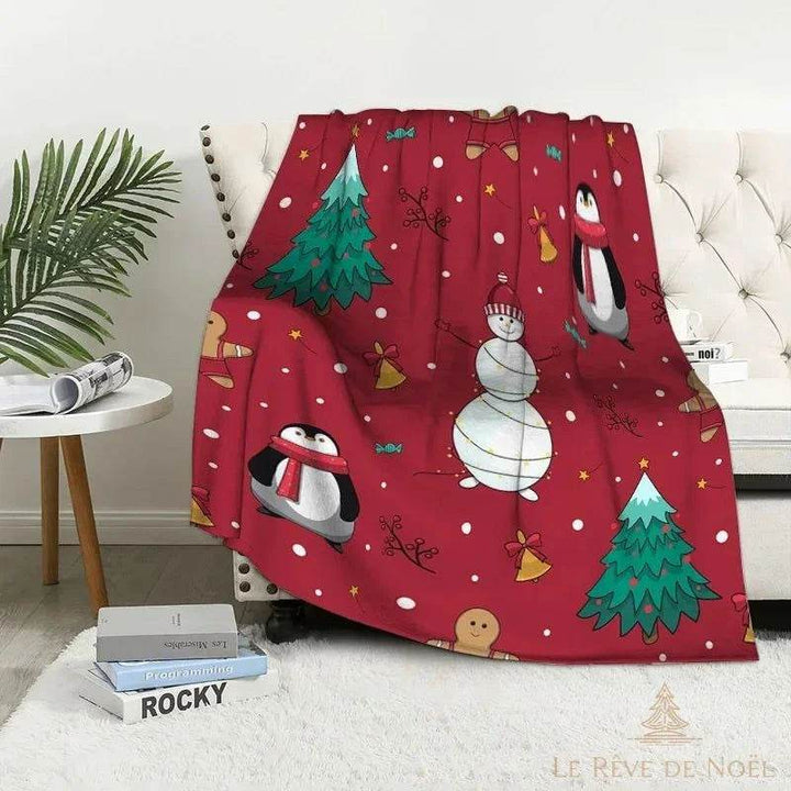 Plaid de Noël rouge illustré de pingouins à écharpe, bonhomme de neige et sapins