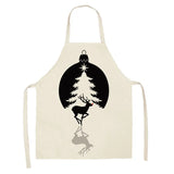 Tablier de Noël blanc, boule noire encadrant un sapin clair, renne noir au nez rouge et son ombre