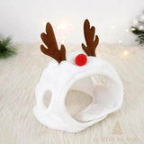 Bonnet de Noël blanc à bois de renne marron et pompon rouge en guise de nez, posé sur une fourrure