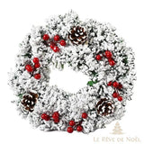 Couronne de Noël blanche givrée avec baies rouges et pommes de pin, fond blanc