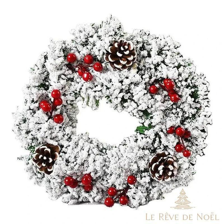 Couronne de Noël blanche givrée avec baies rouges et pommes de pin, fond blanc