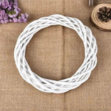 Couronne en osier blanc vue de dessus, posée sur toile de jute avec fleurs séchées violettes