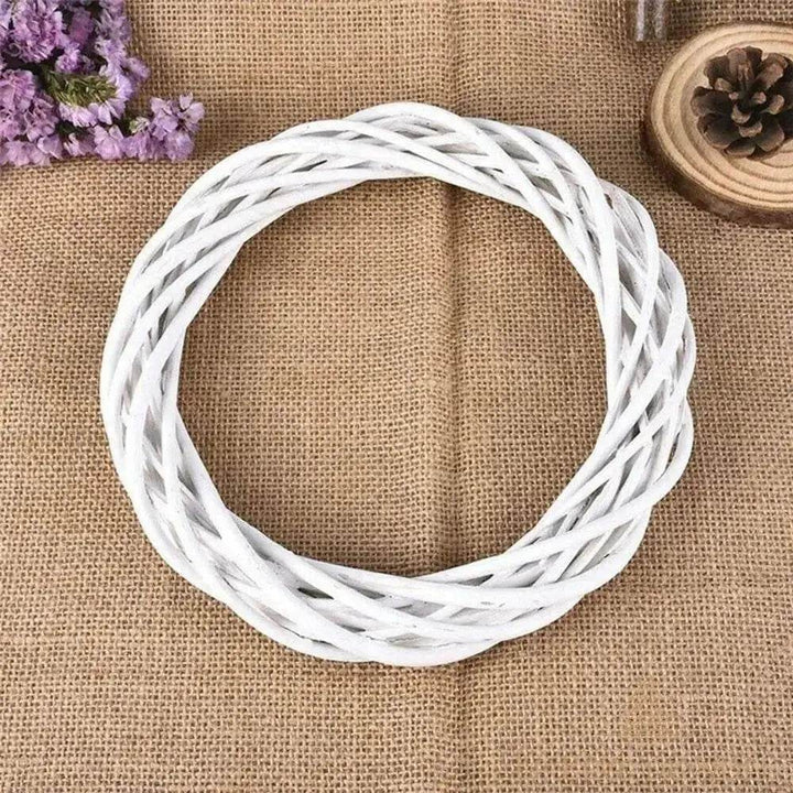 Couronne en osier blanc vue de dessus, posée sur toile de jute avec fleurs séchées violettes