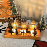 Bougeoir maison de Noël en bois avec deux rennes, bougies allumées, gros plan de nuit