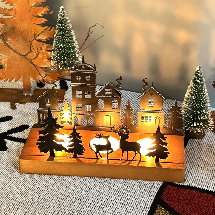 Bougeoir maison de Noël en bois avec deux rennes, bougies allumées, gros plan de nuit