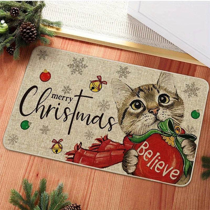 Tapis d'entrée beige avec chat tigré tenant un sac rouge brodé Believe, boules et clochettes