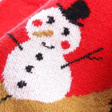 Gros plan tricoté sur le bonhomme de neige du pull rouge, détail des mailles et du chapeau noir