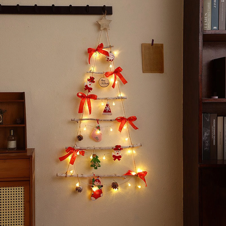Sapin de Noël mural en échelle de bois, nœuds rouges et guirlande lumineuse allumée sur le mur