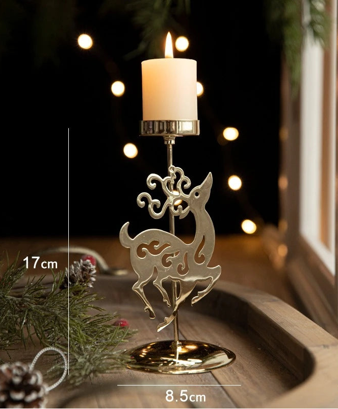 Bougeoir doré en silhouette de renne ajourée, bougie blanche allumée, hauteur 17 cm, base 8,5 cm