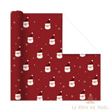 Rouleau de papier cadeau rouge foncé à petits visages de Père Noël, étoiles et flocons, envers blanc