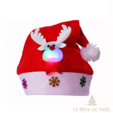 Bonnet de Noël rouge et blanc, tête de renne à bois blancs et museau lumineux en gros plan
