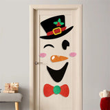 Sticker visage de bonhomme de neige collé sur une porte en bois clair