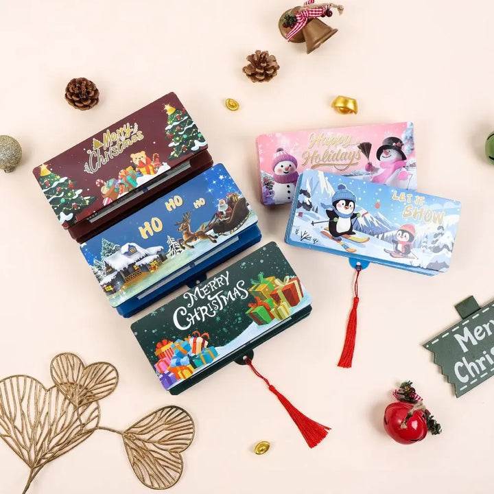 Quatre pochettes cadeau de Noël bordeaux, bleu marine, bleu ciel et rose, empilées avec pommes de pin et clochettes