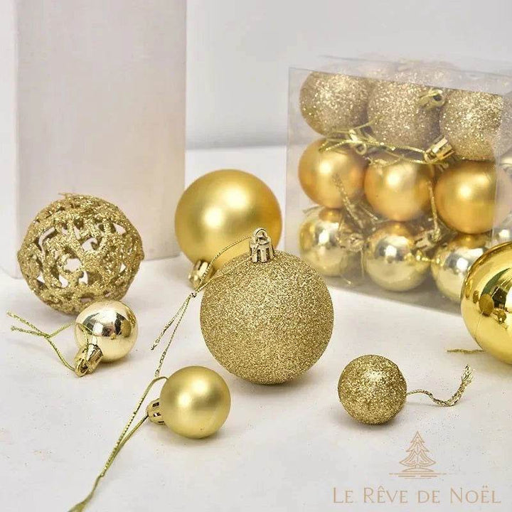 Boules de Noël dorées de finitions variées, brillante, mate, pailletée et ajourée, dans une boîte