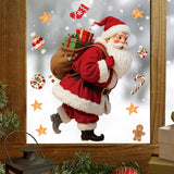 Stickers Père Noël et friandises collés sur une fenêtre en bois, neige visible derrière la vitre