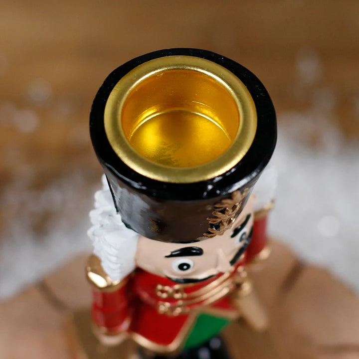 Gros plan sur la cavité dorée creusée au sommet du chapeau du casse-noisette, pour une bougie