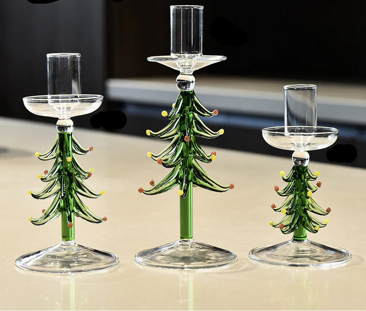 Trois bougeoirs sapin en verre de tailles différentes, sans bougie, sur un plan de travail