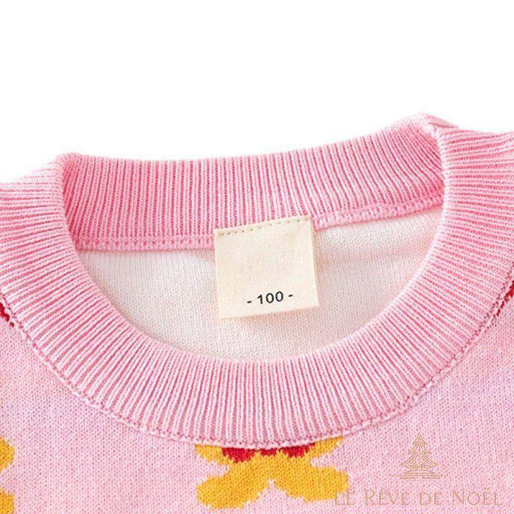 Gros plan sur l'encolure rose du pull, étiquette de taille « 100 » cousue à l'intérieur
