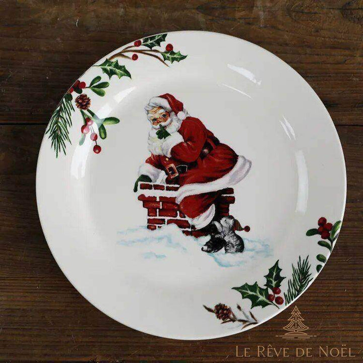 Assiette bordée de houx, Père Noël assis sur une cheminée en briques, chaton blotti en dessous