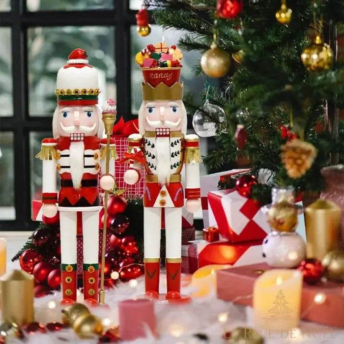 Deux casse-noisette géants rouge, blanc et or devant un sapin de Noël décoré et des cadeaux