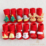 Six paires de chaussettes de Noël bébé rouges alignées, appliques sapin, renne, cloche, Père Noël