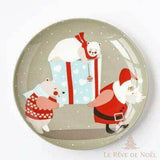 Sous-assiette grise montrant un Père Noël portant un cadeau entouré de deux oursons