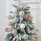 Boules de Noël perlées multicolores accrochées sur un grand sapin de Noël enneigé, vue d'ensemble