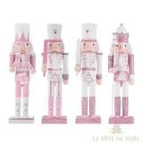 Quatre casse-noisette roses et blancs : musicien, deux porte-épée et un roi couronné