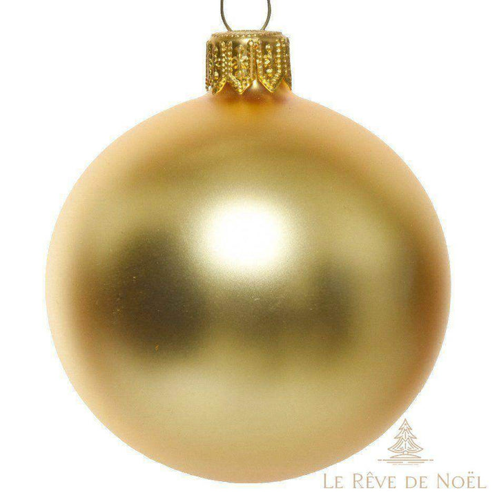 Boule de Noël dorée mate en gros plan, capsule dorée assortie, sur fond blanc