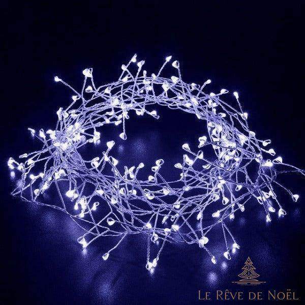 Guirlande lumineuse enroulée, allumée en blanc froid bleuté, sur fond noir