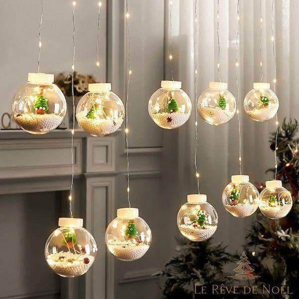 Rideau lumineux de boules transparentes contenant un mini sapin vert, lumières blanc chaud