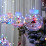 Rideau de boules lumineuses multicolores avec une figurine de Père Noël miniature à l'intérieur