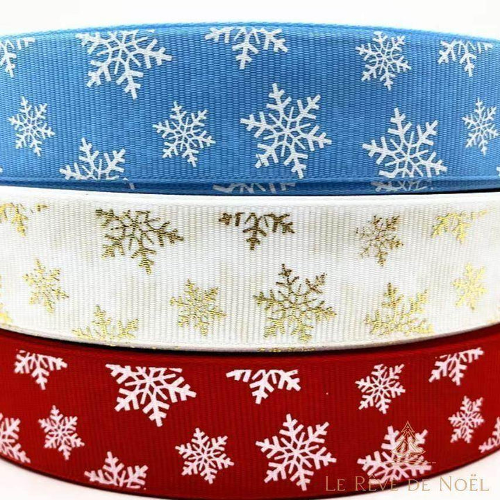 Trois rouleaux de ruban de Noël en tissu empilés : bleu, blanc et rouge à flocons de neige