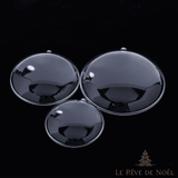 Trois boules plates en plastique transparent de tailles différentes, fermées, sur fond noir