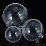 Boules en plastique transparent de trois tailles, vides, posées sur fond noir