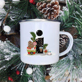 Mug émaillé blanc à lettre I noire décorée d'un cupcake et d'une pomme de pin, sur fond étoilé
