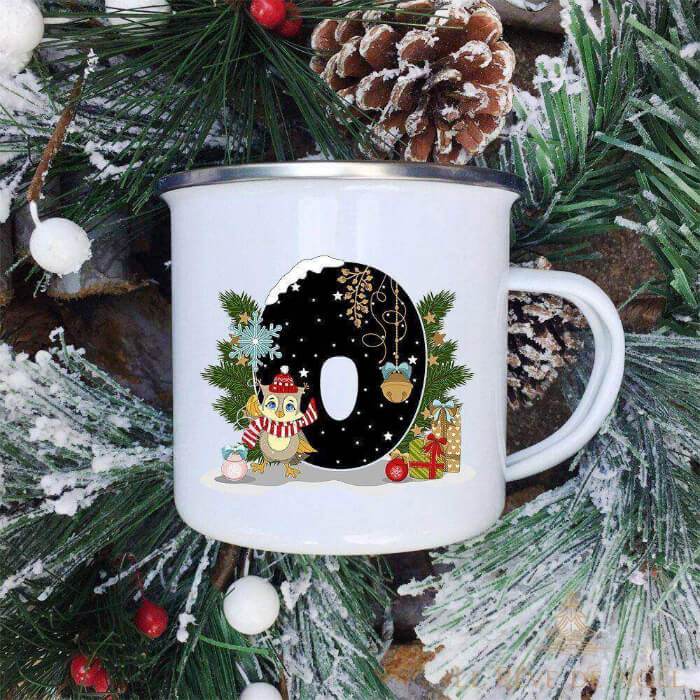 Mug émaillé blanc à lettre O noire ornée d'une chouette à bonnet rouge et écharpe rayée à côté
