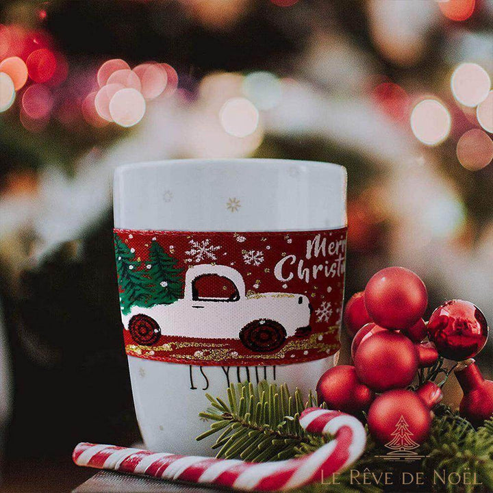 Mug entouré d'un ruban rouge à motif camionnette et sapins, sucre d'orge et houx