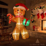Bonhomme en pain d'épice gonflable lumineux, posé près d'une cheminée décorée de chaussettes