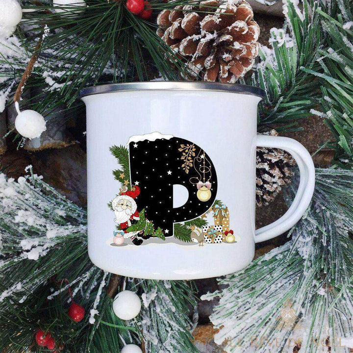 Mug émaillé blanc à lettre P noire décorée d'un Père Noël et de cadeaux à pois, branches de sapin givrées