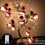 Guirlande de bonhommes de neige en peluche enroulée sur un arbre décoratif à branches lumineuses