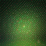 Gros plan sur les points lumineux rouges et verts projetés par le projecteur de Noël sur un mur
