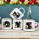 Quatre mugs en émail blanc à bord argenté formant les lettres L, O, V, E, motifs de Noël