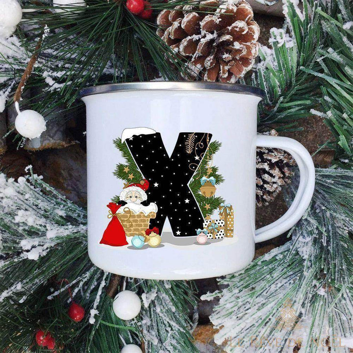 Mug émaillé blanc à lettre X noire ornée d'un Père Noël portant une hotte et un sac de cadeaux rouge