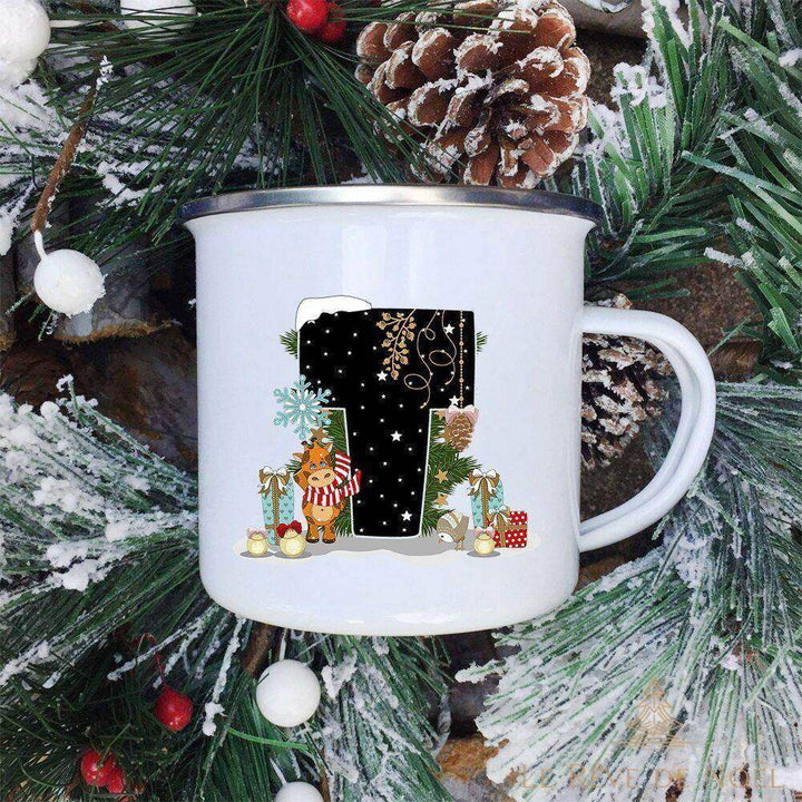 Mug lettre T orné d'un renne à écharpe rayée et de petits cadeaux, sur fond de sapin enneigé