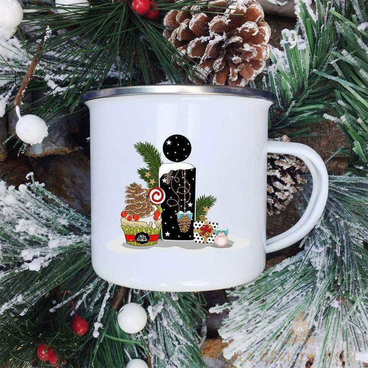 Mug lettre I entouré d'un cupcake glacé, de pommes de pin et d'un cadeau à pois
